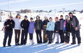 “Group of young friends enjoying après at Beach Burrito Jindabyne with snow-covered mountains in the background”