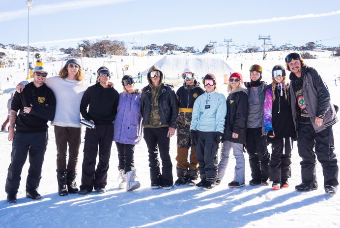 “Group of young friends enjoying après at Beach Burrito Jindabyne with snow-covered mountains in the background”